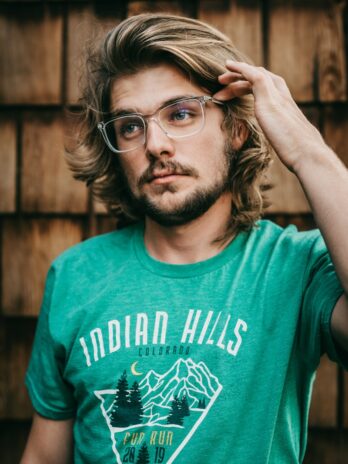 man in green crew neck t-shirt wearing black framed eyeglasses